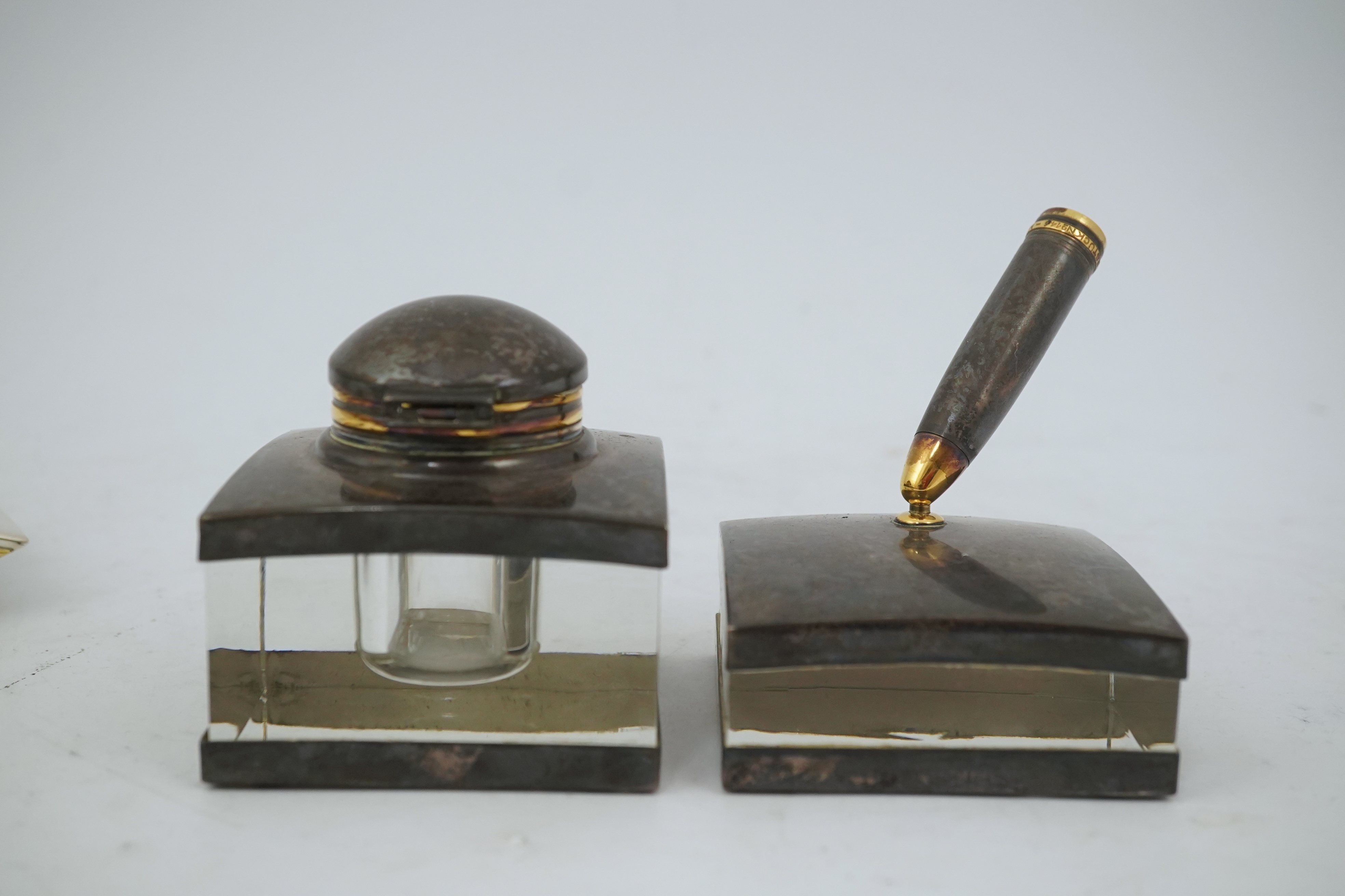 A Montblanc three piece German silver and glass desk set comprising pen stand, inkwell and blotter, each glass mounted, silver engraved with the Montblanc logo